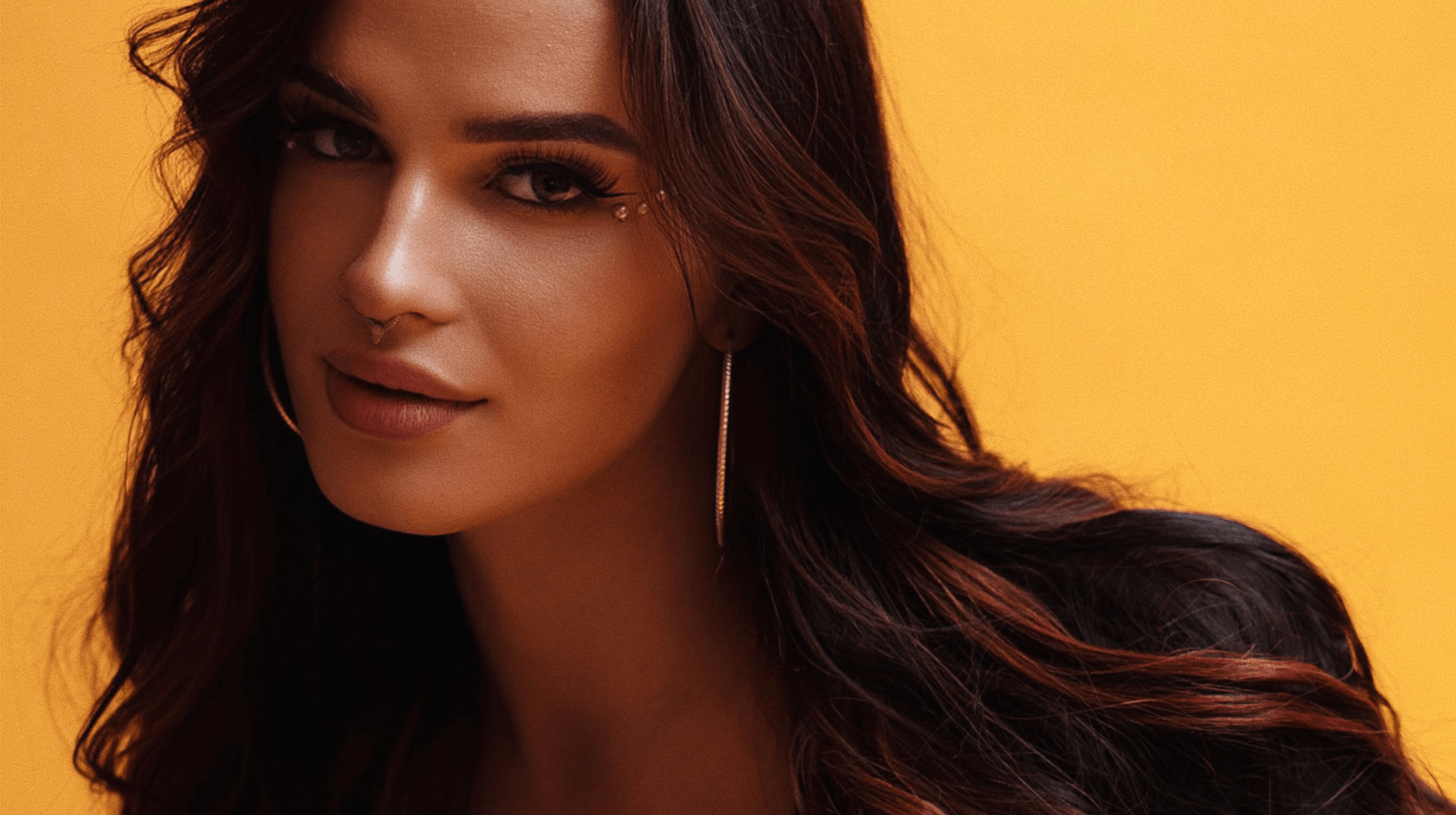 Woman with long black hair looking into the camera