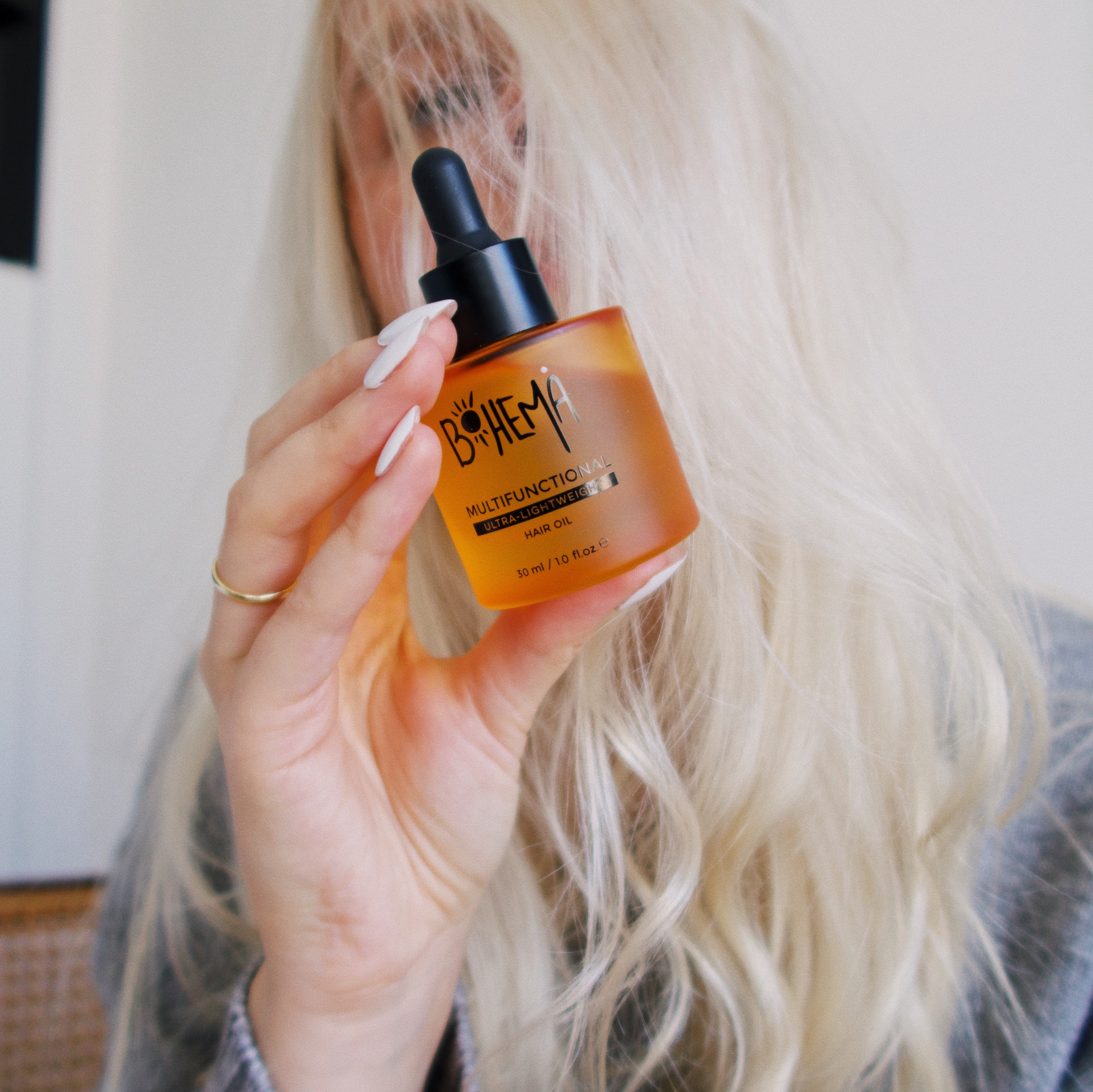 Picture of happy customer, holding BOHEMA HAIR Oil bottle