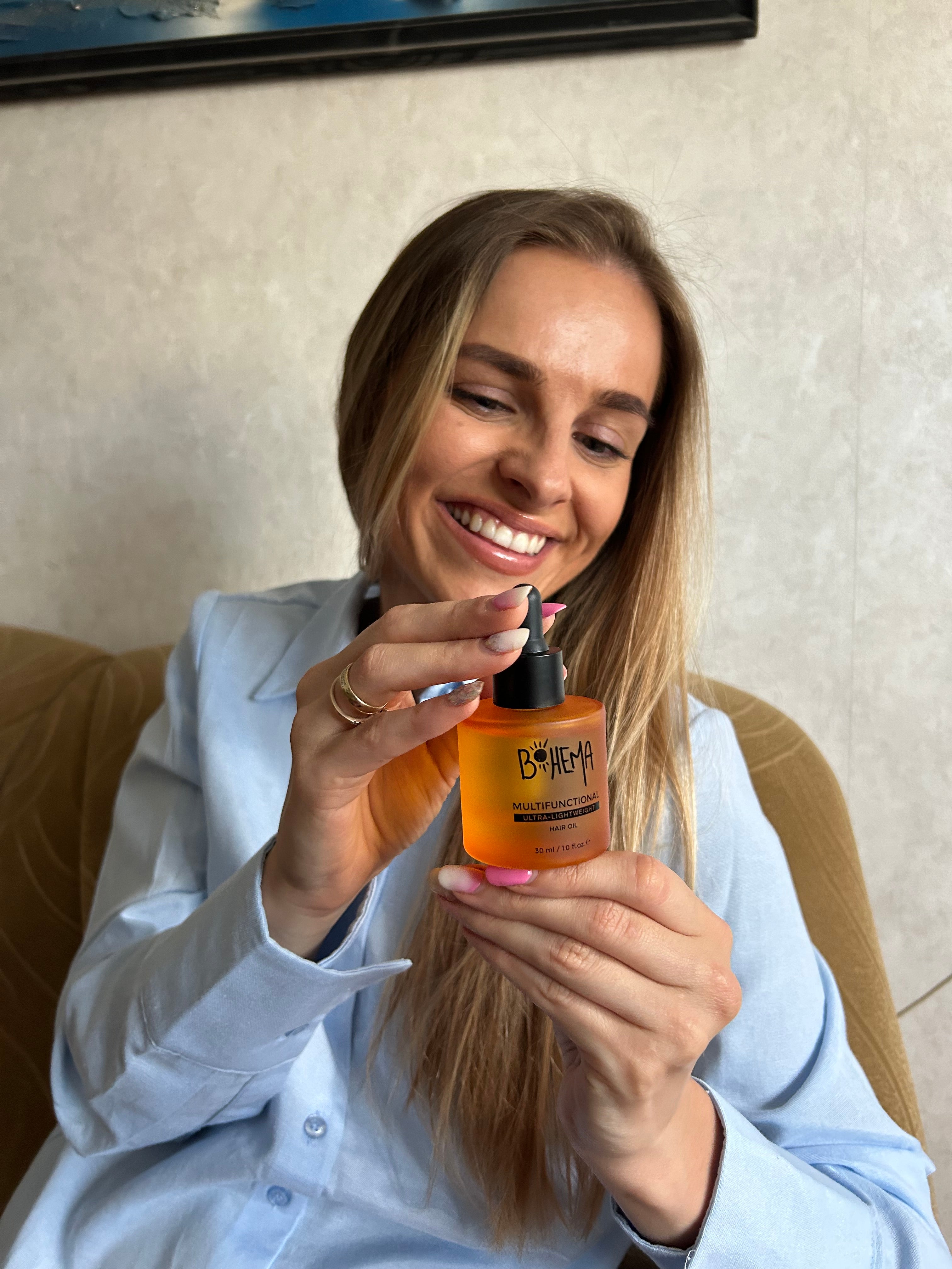 Picture of happy customer, holding BOHEMA HAIR Oil bottle