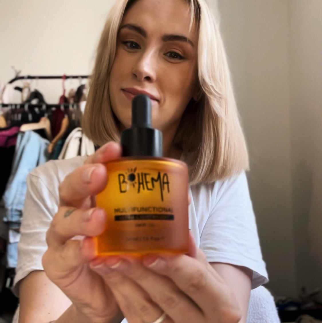 Picture of happy customer, holding BOHEMA HAIR Oil bottle